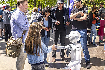 Der Zukunft die Hand schütteln: Besucherinnen und Besucher begegnen humanoiden Robotern hautnah.